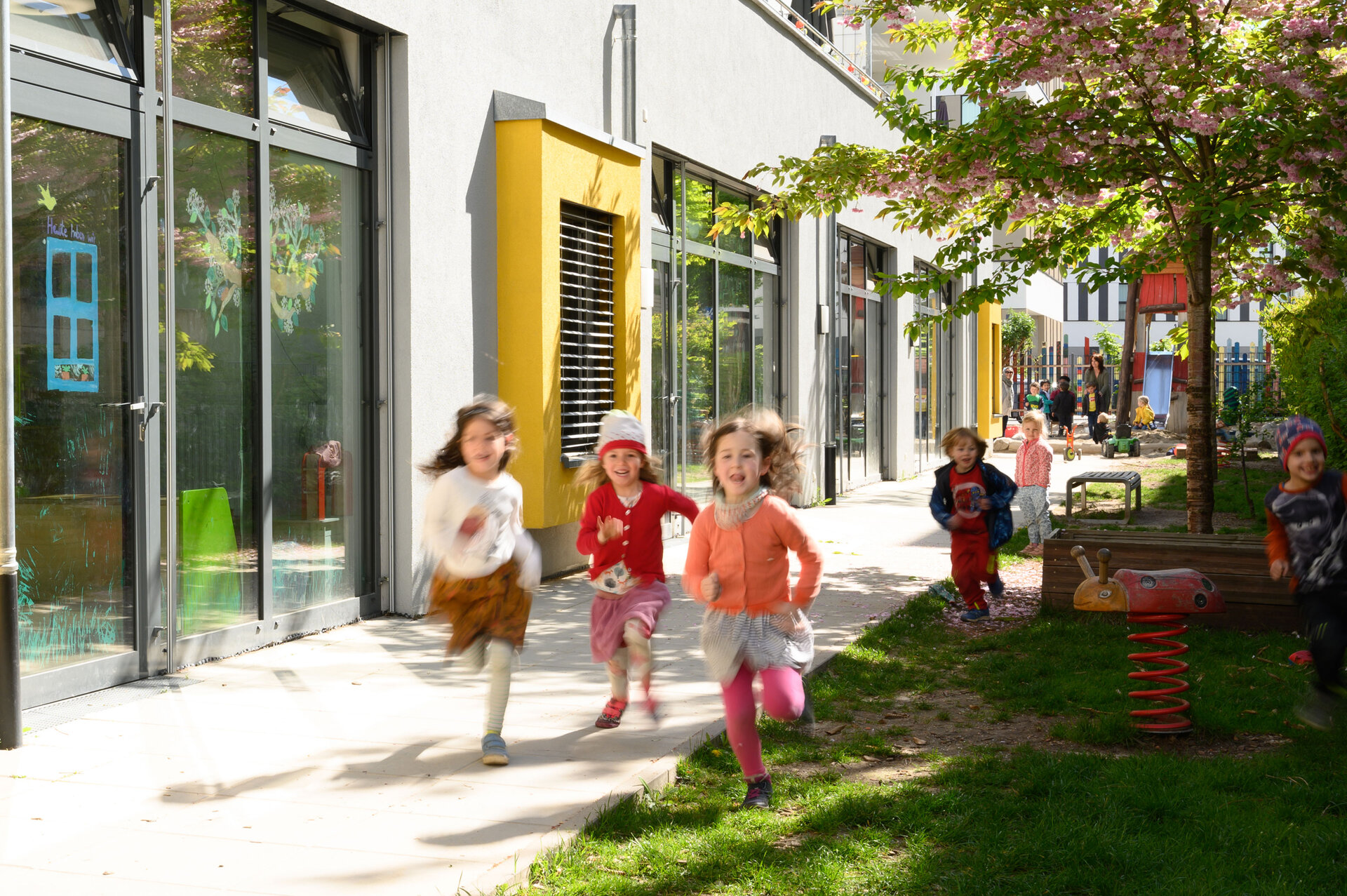 Rennende Kinder in einem Garten einer KiTa